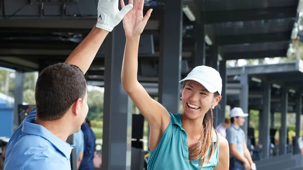 Golfer celebrating with a Toptracer screen at PG by Magna Marbella Golf