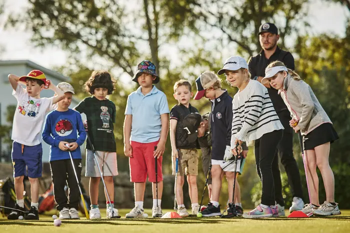 Coach guiding a family lesson at PG Golf and Sports Academy